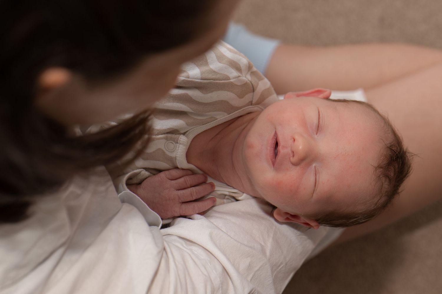 Baby smiling during candid newborn photography session at home