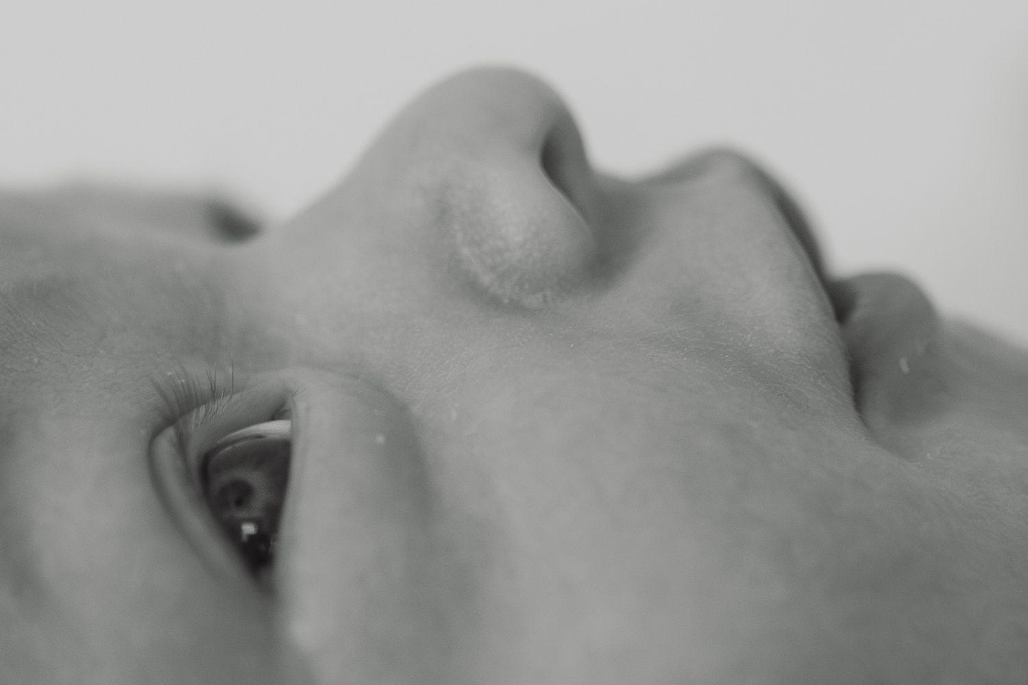 Extreme close-up black and white portrait of a newborn baby's delicate facial features.