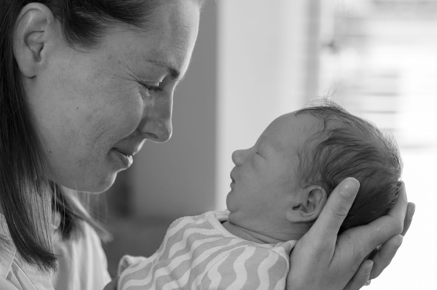 Mother smiling at her baby during photography session at home in Dorset, UK
