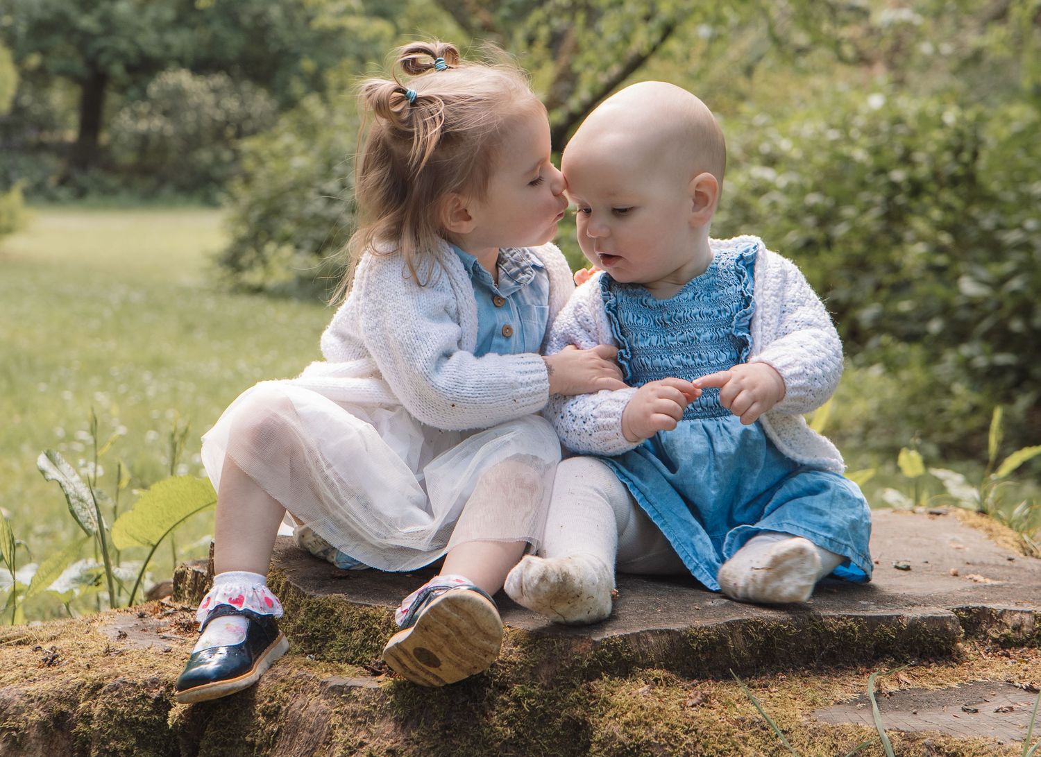 Candid moment of siblings sharing a tender moment during outdoor photoshoot