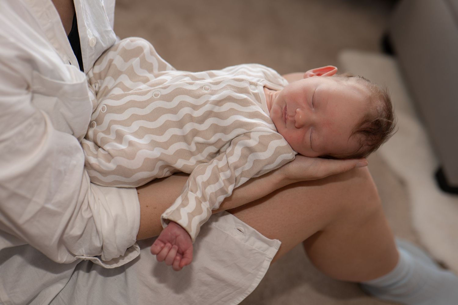 Baby sleeping on mother during documentary-style photography session at home