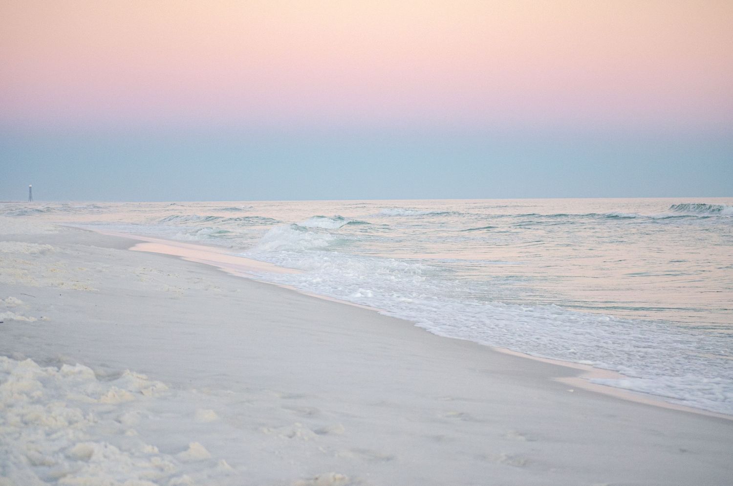 A peaceful emerald coast sunset with soft waves and golden evening light