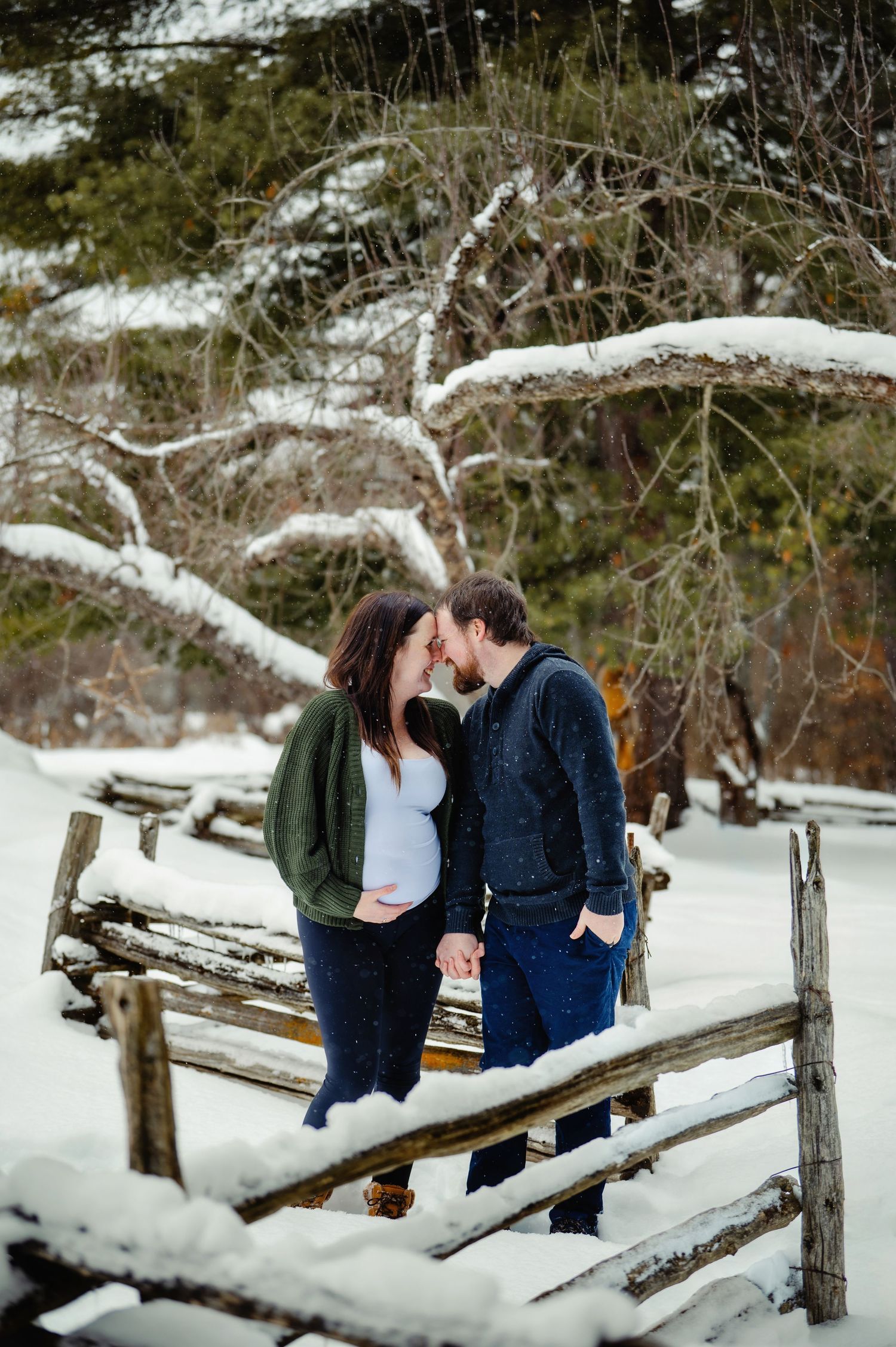 Mom and dad touching foreheads while mom holds belly. Ottawa Maternity Photography. Ottawa Family Photographer.