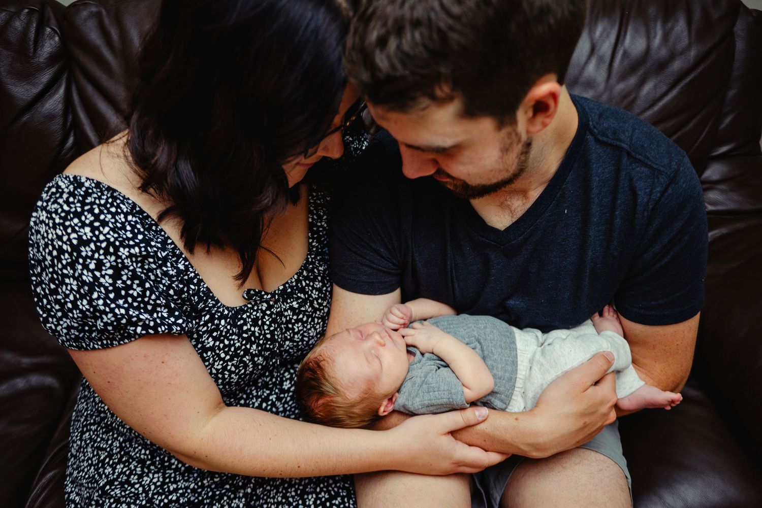 Mom and dad holding newborn son in arms. Ottawa Newborn Photography. Ottawa Family Photography
