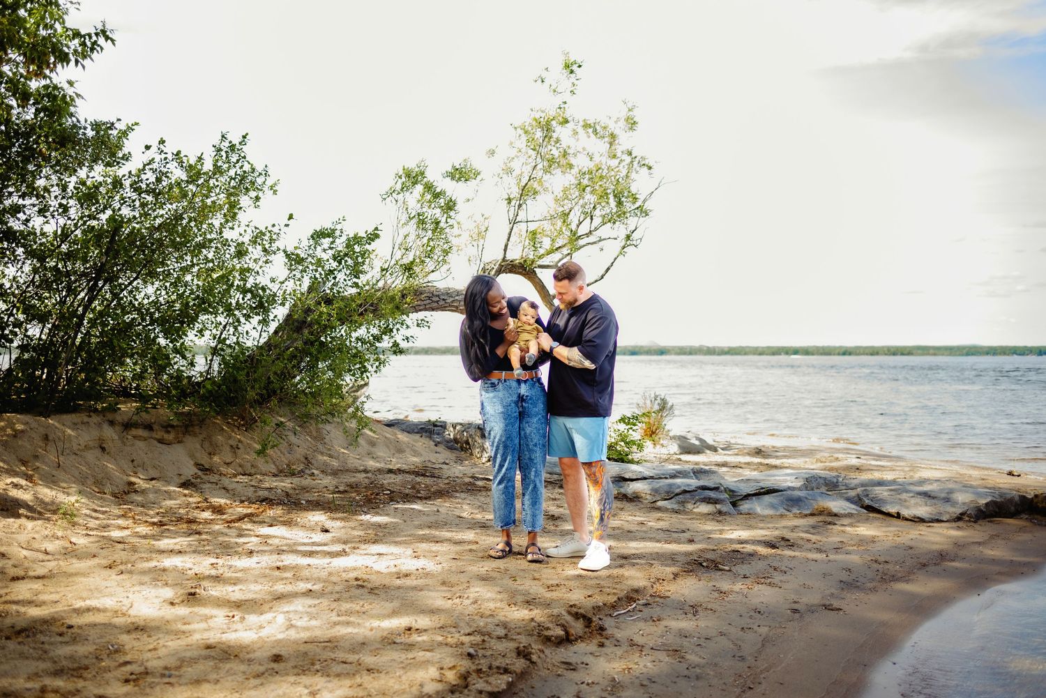 Family cuddled on beach in summer. Ottawa Family Photography