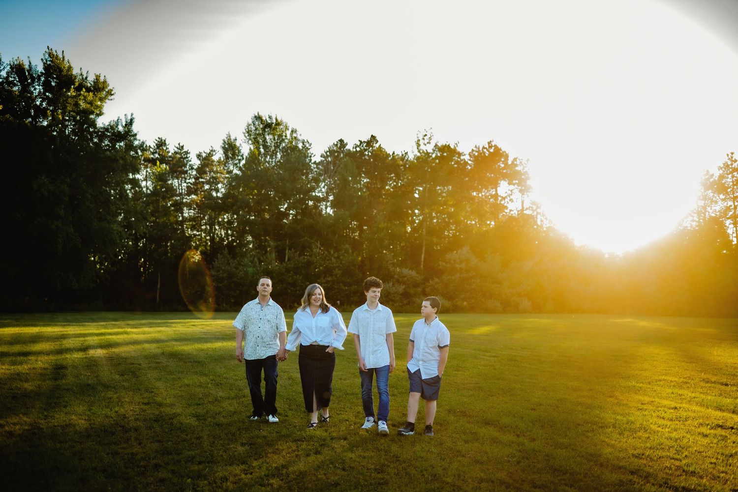 Mom and dad walking with teen sons with sunset. Ottawa Family Photography.