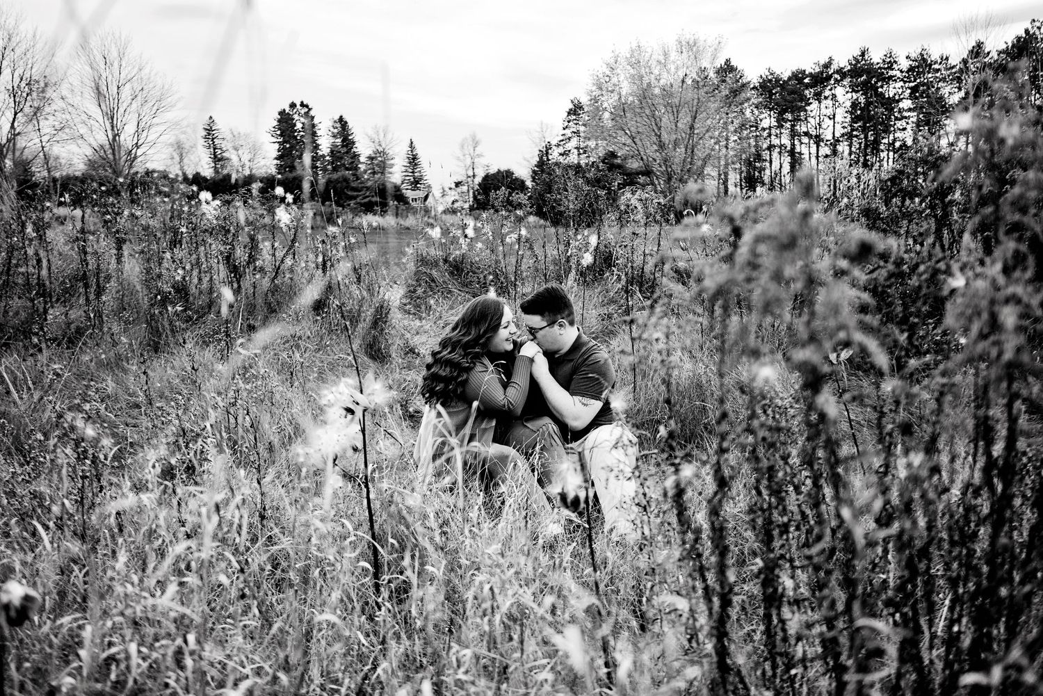 Soon to be husband kissing Fiancés hand in the tall grass. Ottawa Wedding Photographer. Ottawa Couples Photographer