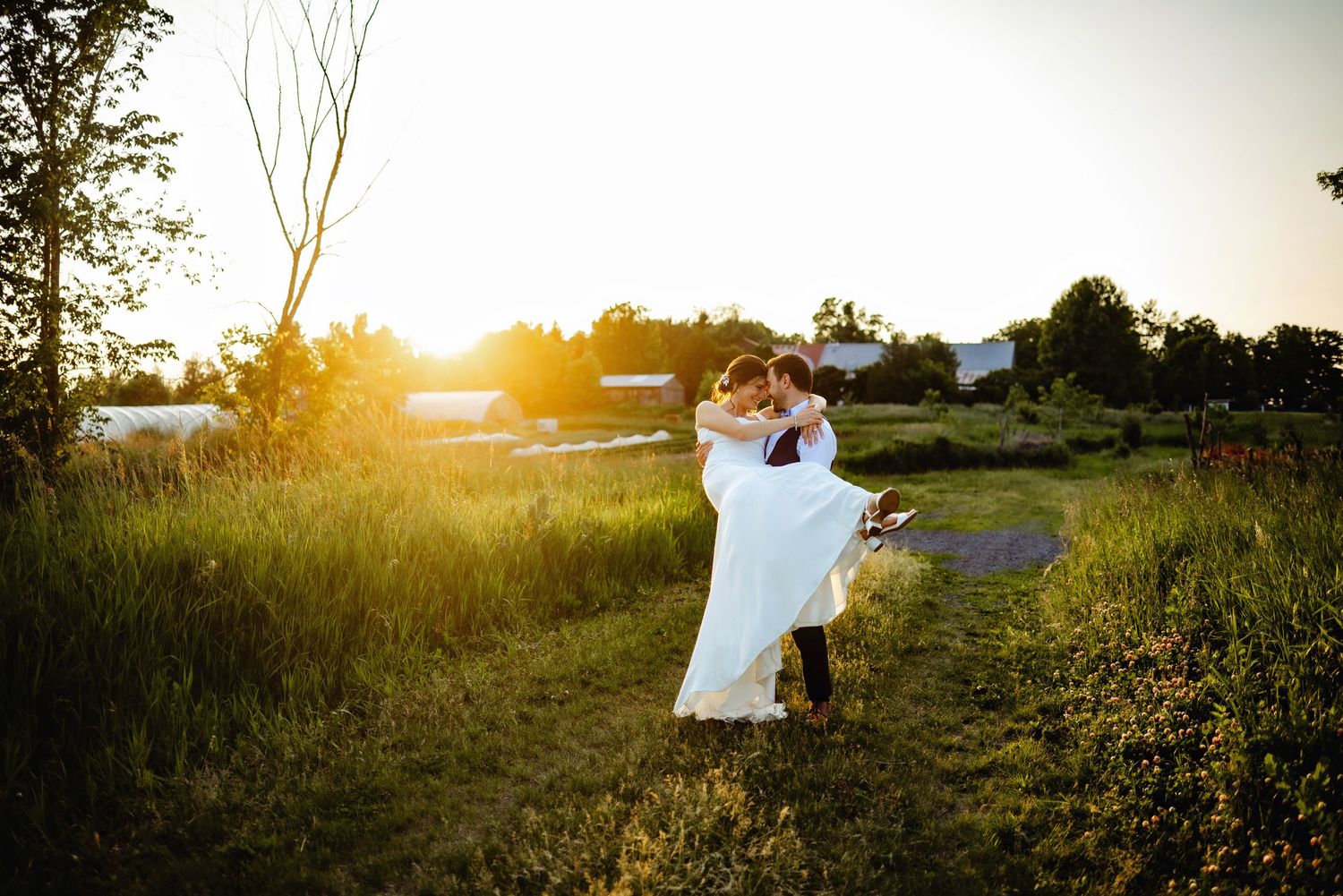 Groom carrying bride while spinning her around during sunset. Ottawa Wedding Photography. Ottawa Wedding Videography.