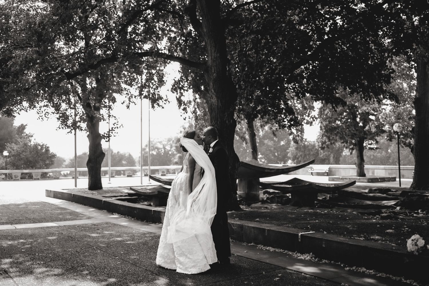 Bride and groom kissing while veil wraps around them. Ottawa Wedding Photography. Ottawa Wedding Videography.