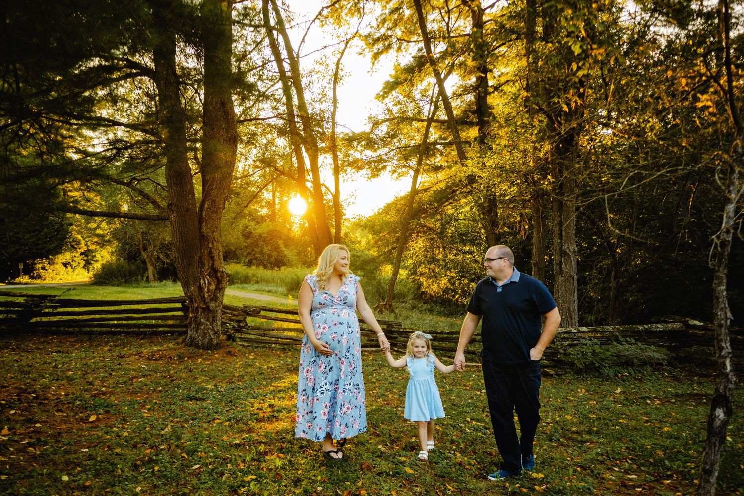 Family walking in sunset while mom holds baby belly. Ottawa Maternity Photography. Ottawa Family Photographer.