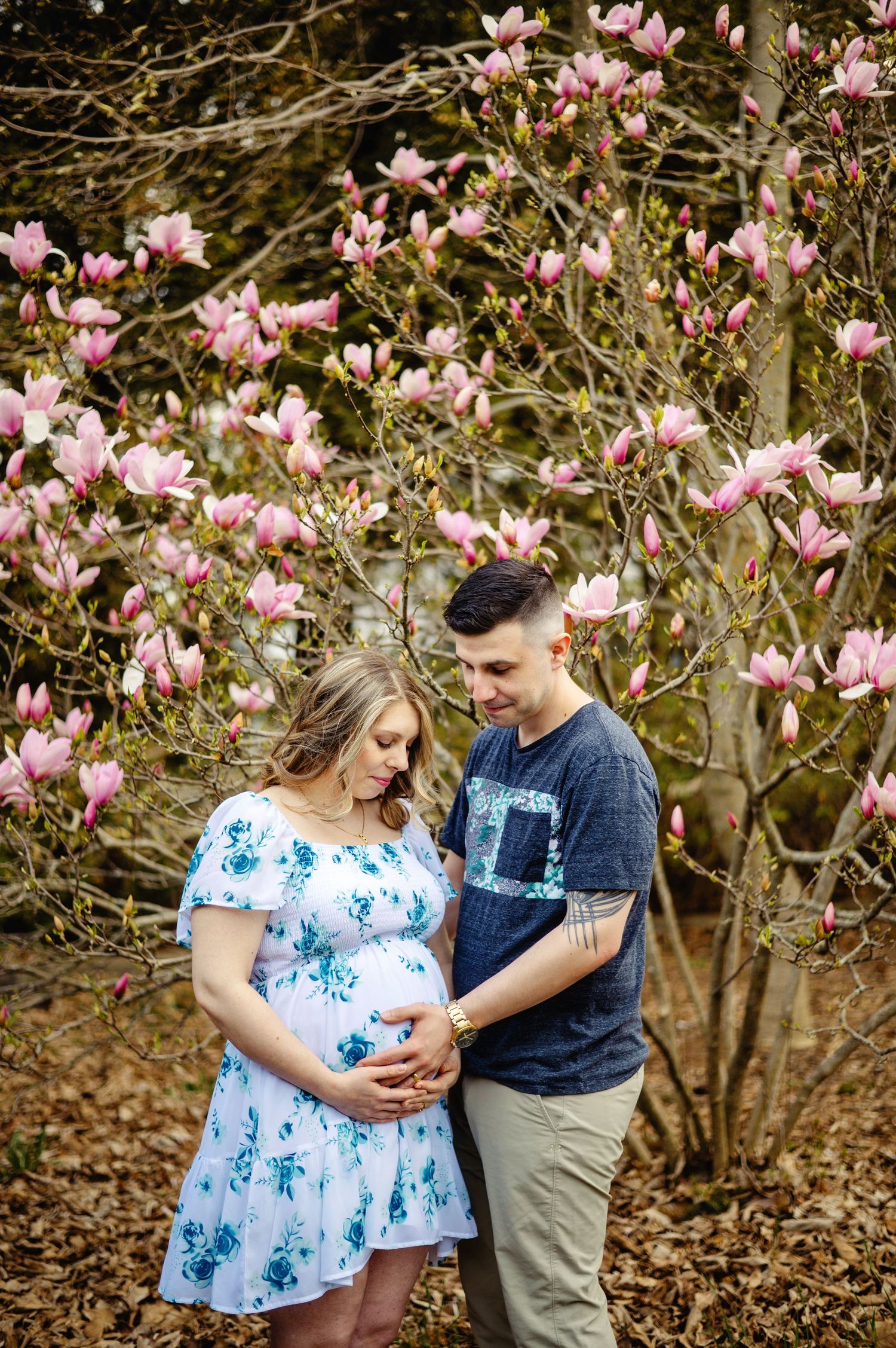 Dad holding mom's belly upon cherry blossoms. Ottawa Maternity Photographer