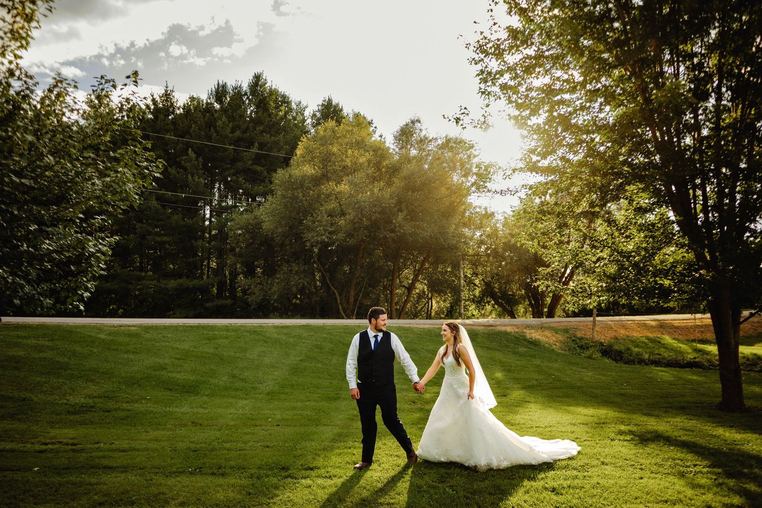 Groom leading bride as they walk in the sunset. Ottawa Wedding Photography. Ottawa Wedding Videography.