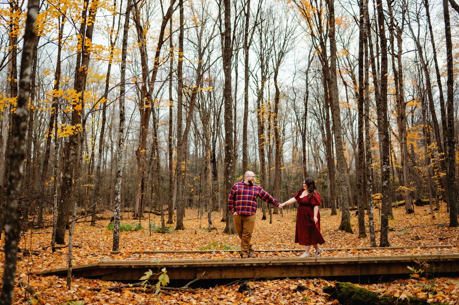 Couple walking across bridge in fall. Ottawa Wedding Photographer. Ottawa Couples Photographer