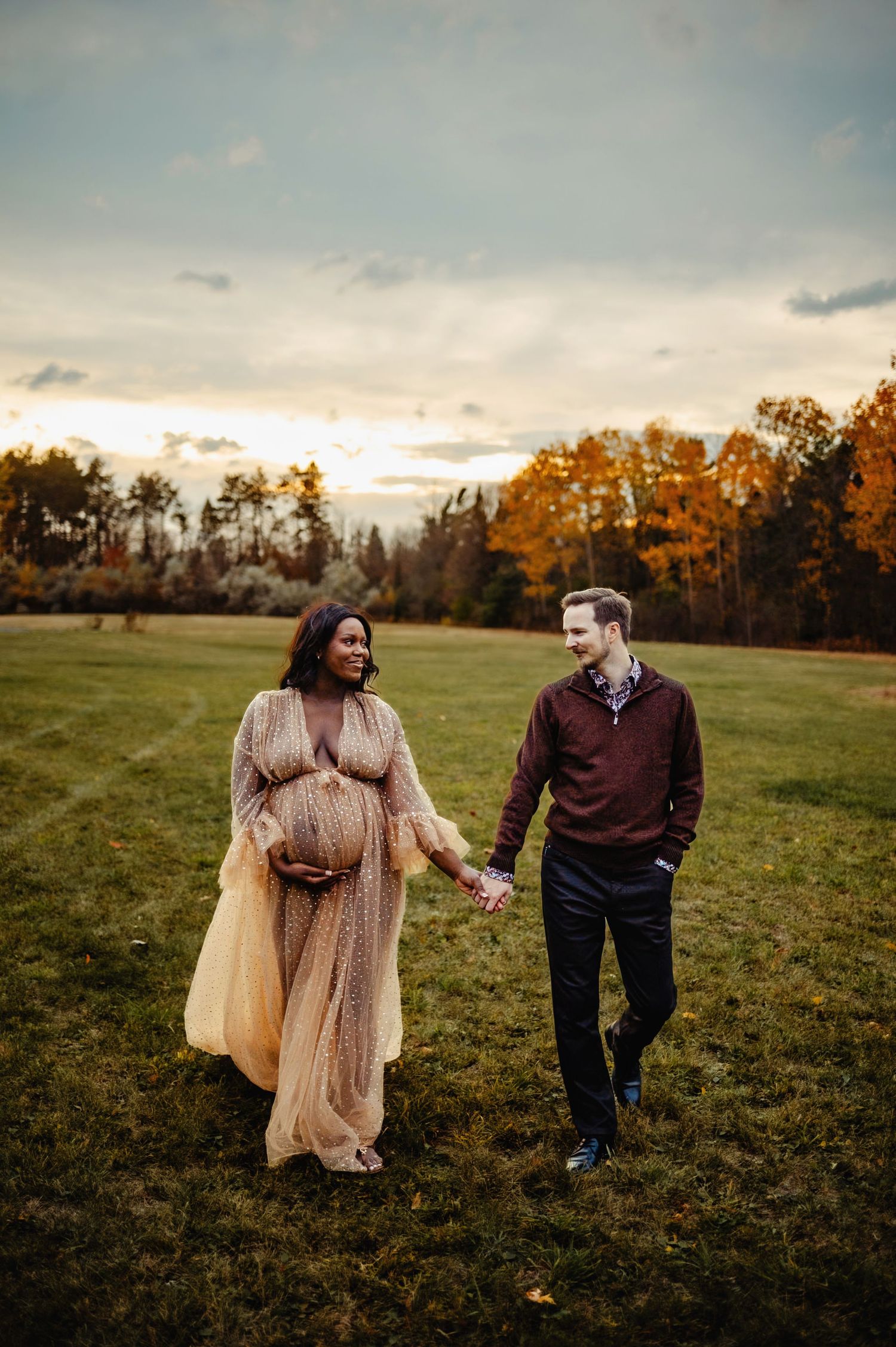 Mom and Dad walking while mom holds baby belly. Ottawa Maternity Photography. Ottawa Family Photographer.