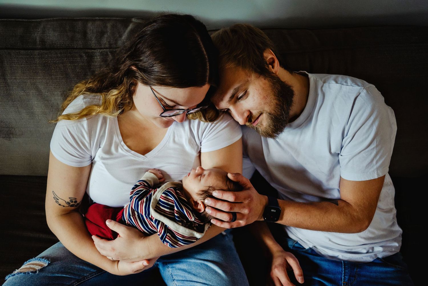 Mom and dad holding newborn son looking at him. Ottawa Newborn Photography. Ottawa Family Photography