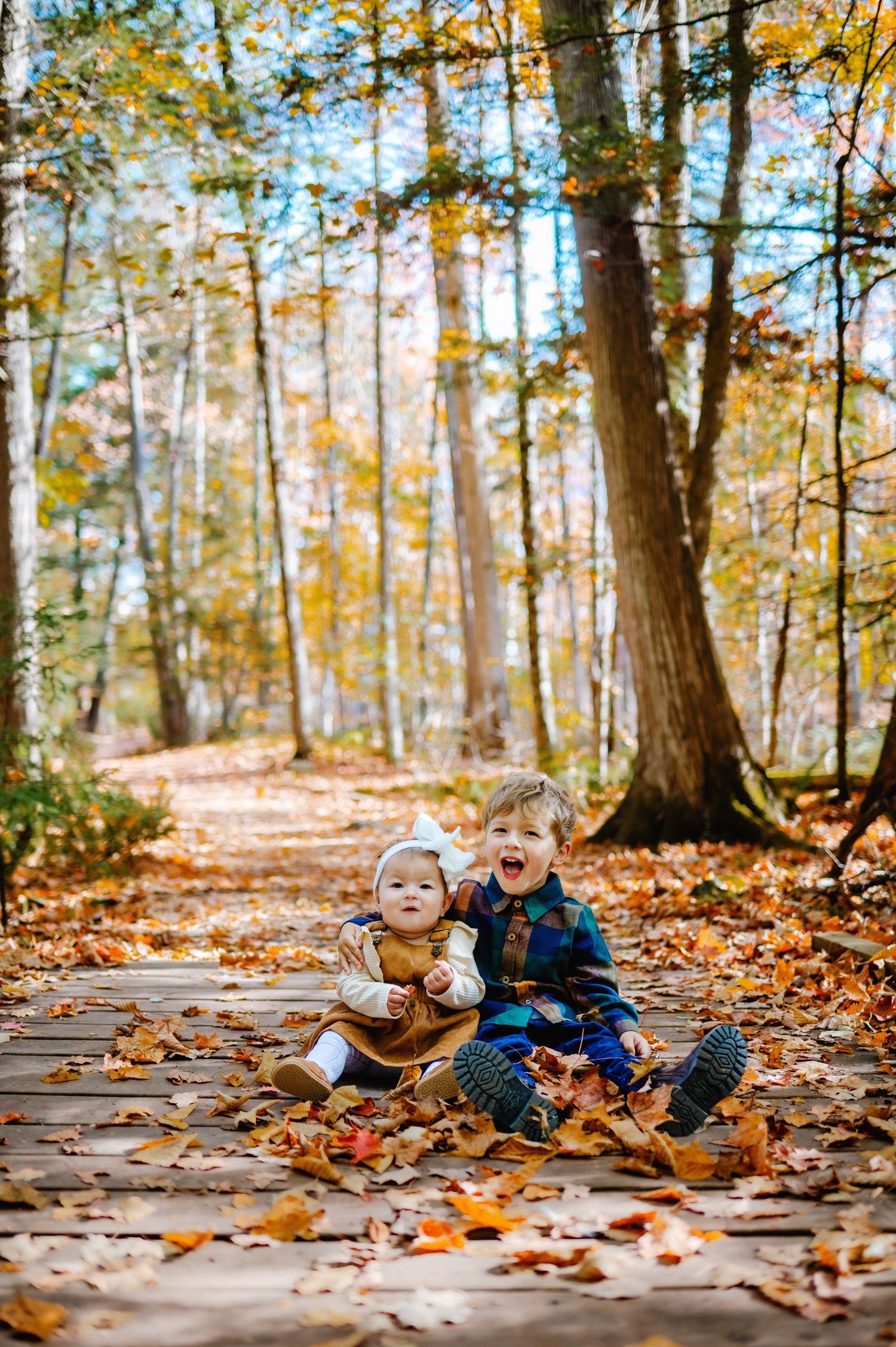 Siblings hugging in fall leaves. Ottawa Family Photographer. Ottawa Fall Minis Photographer