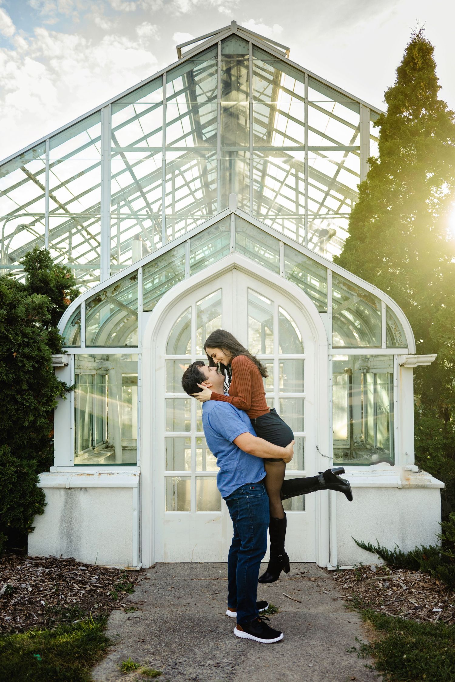 Soon to be husband spinning soon to be bride around in front of greenhouse. Ottawa Wedding Photographer. Ottawa Couples Photographer