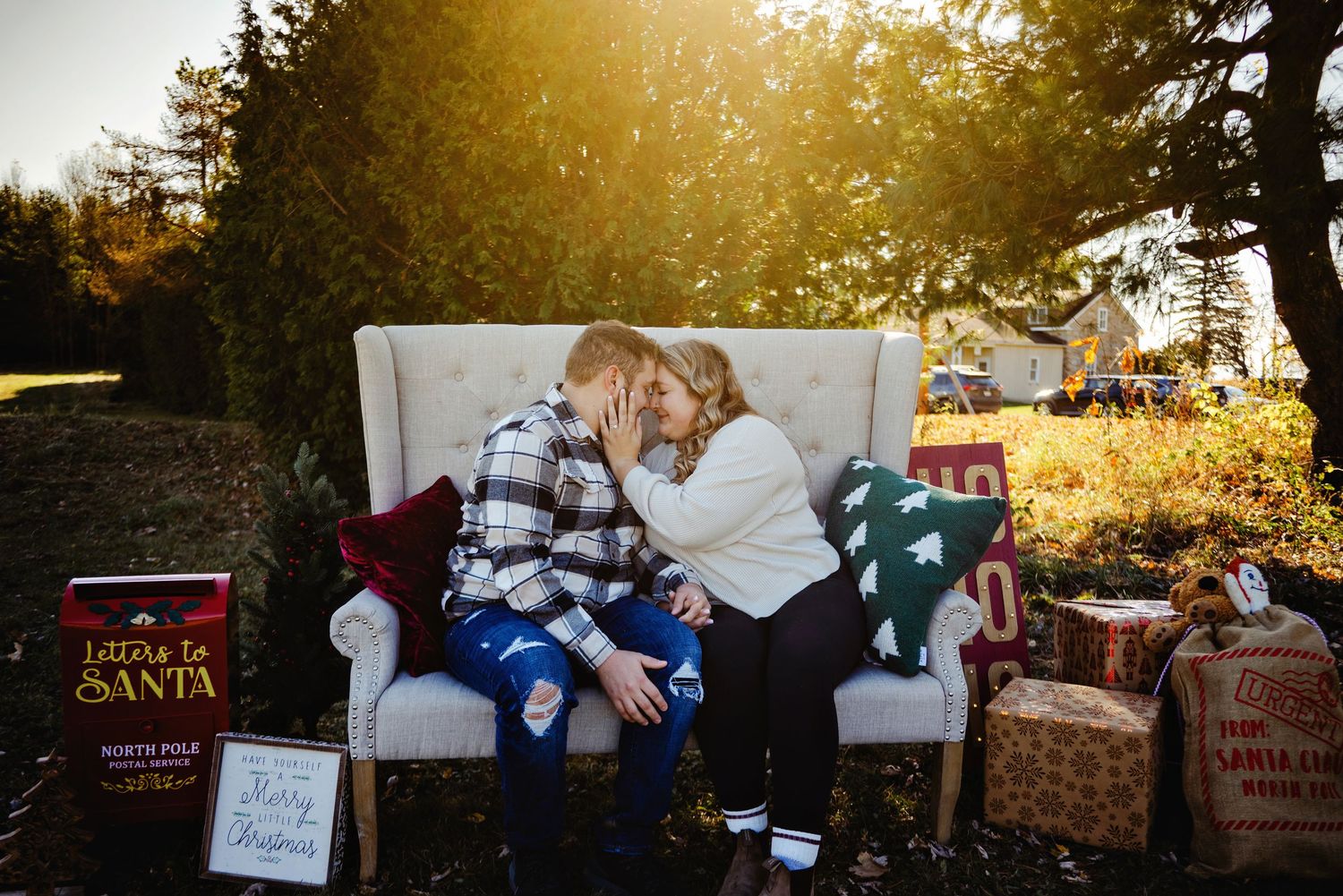 Couple sitting on large couch with Christmas decor. Ottawa Christmas Mini Photography