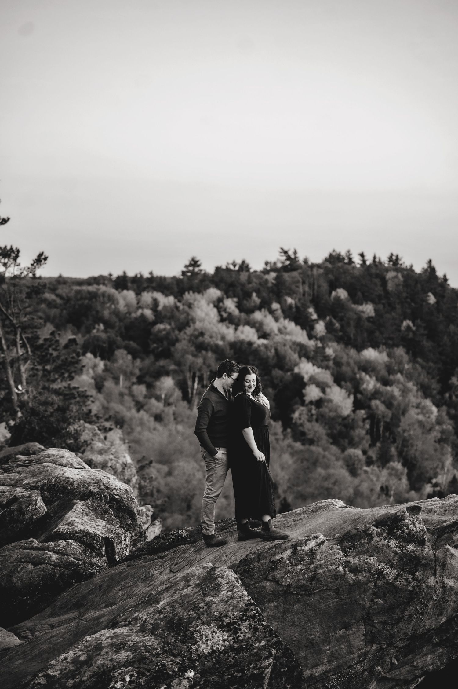 Engaged couple standing on rocks edge at Eagles Nest Lookout in Calabogie. Ottawa Wedding Photographer. Ottawa Couples Photographer.