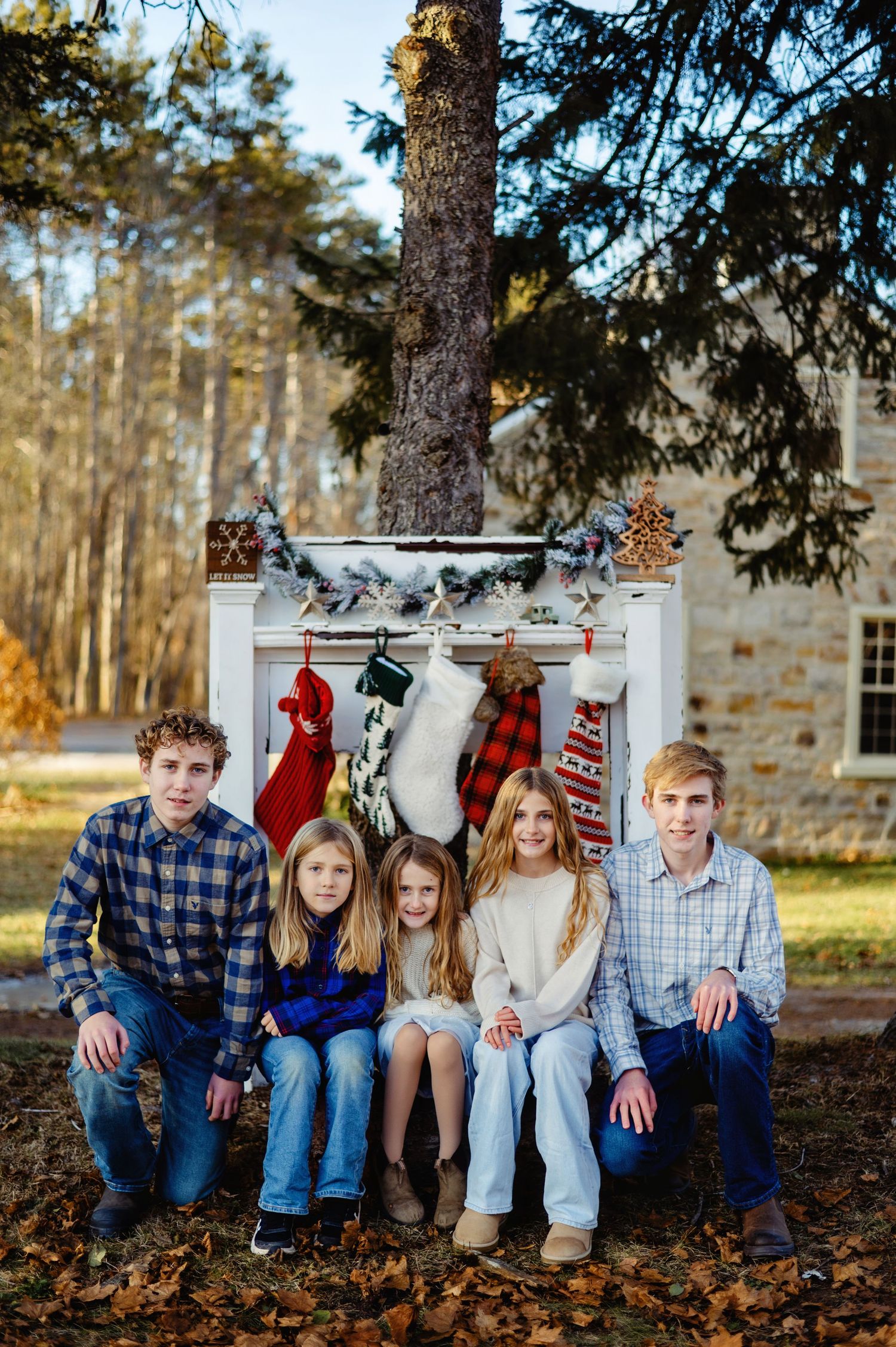 Family sitting by fireplace with stockings hanging. Ottawa Christmas Mini Photography