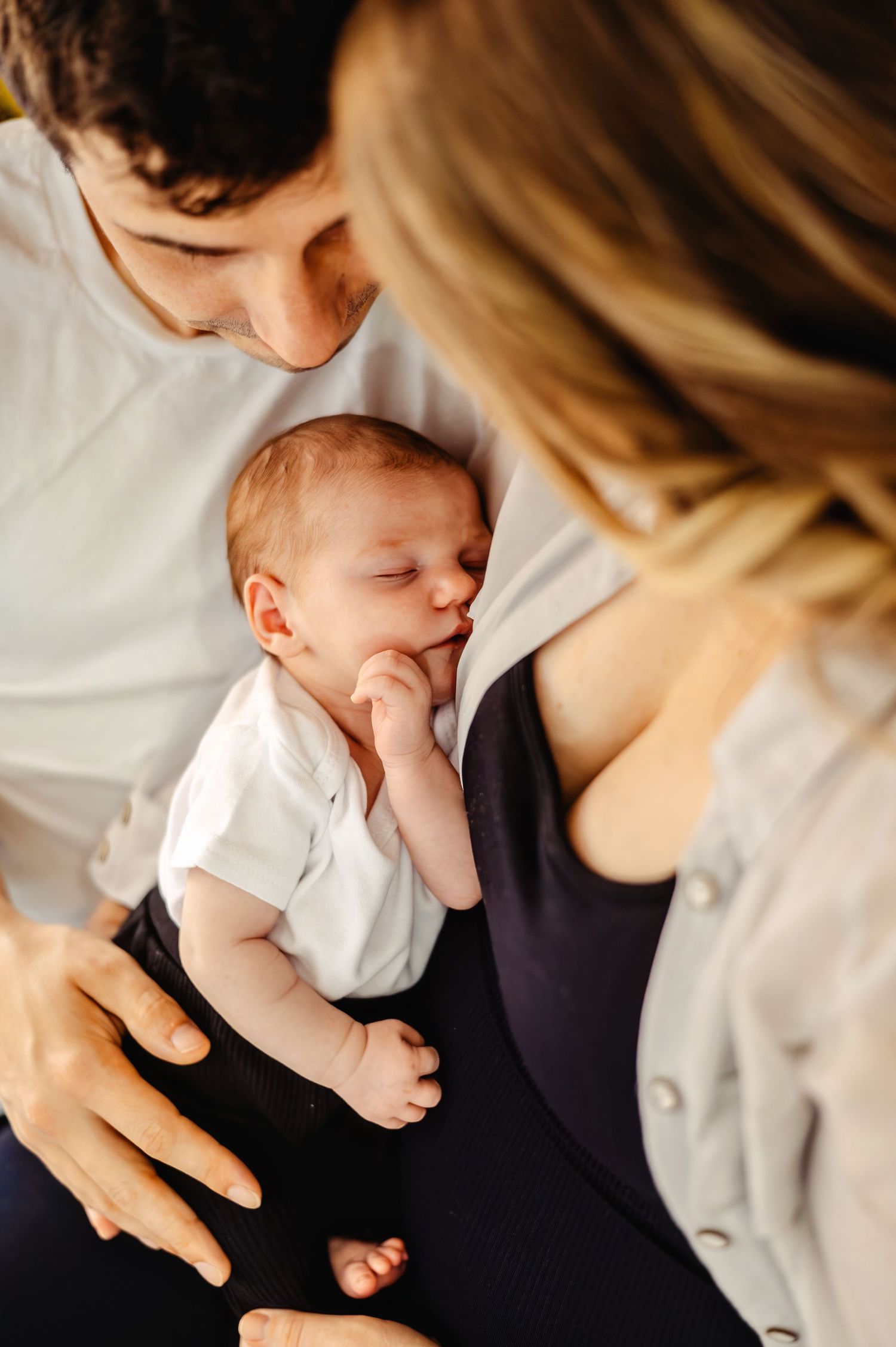 Newborn daughter sleeping cuddled with Mom and Dad. Ottawa Newborn Photography. Ottawa Family Photography