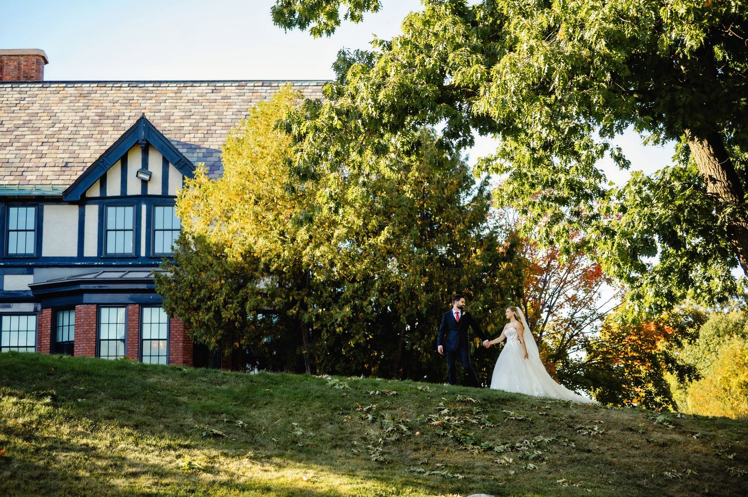 Bride and Groom walking up hill towards venue. Ottawa Wedding Photography. Ottawa Wedding Videography.