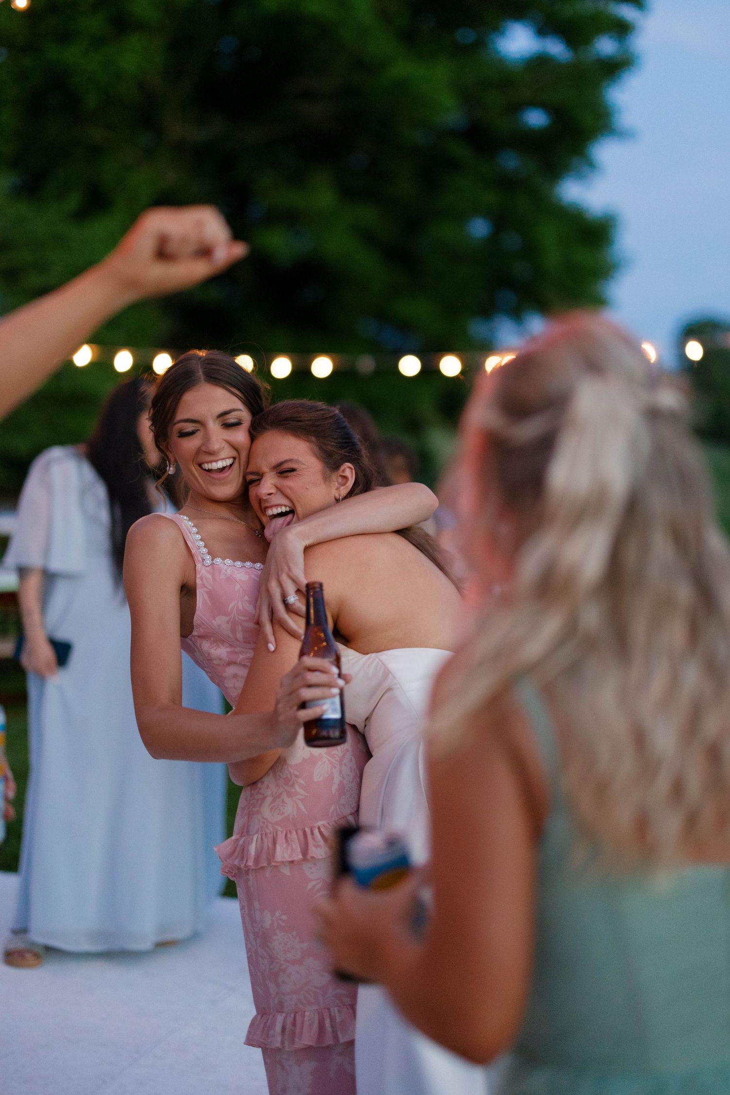Guests celebrating and dancing joyfully at an outdoor wedding reception.