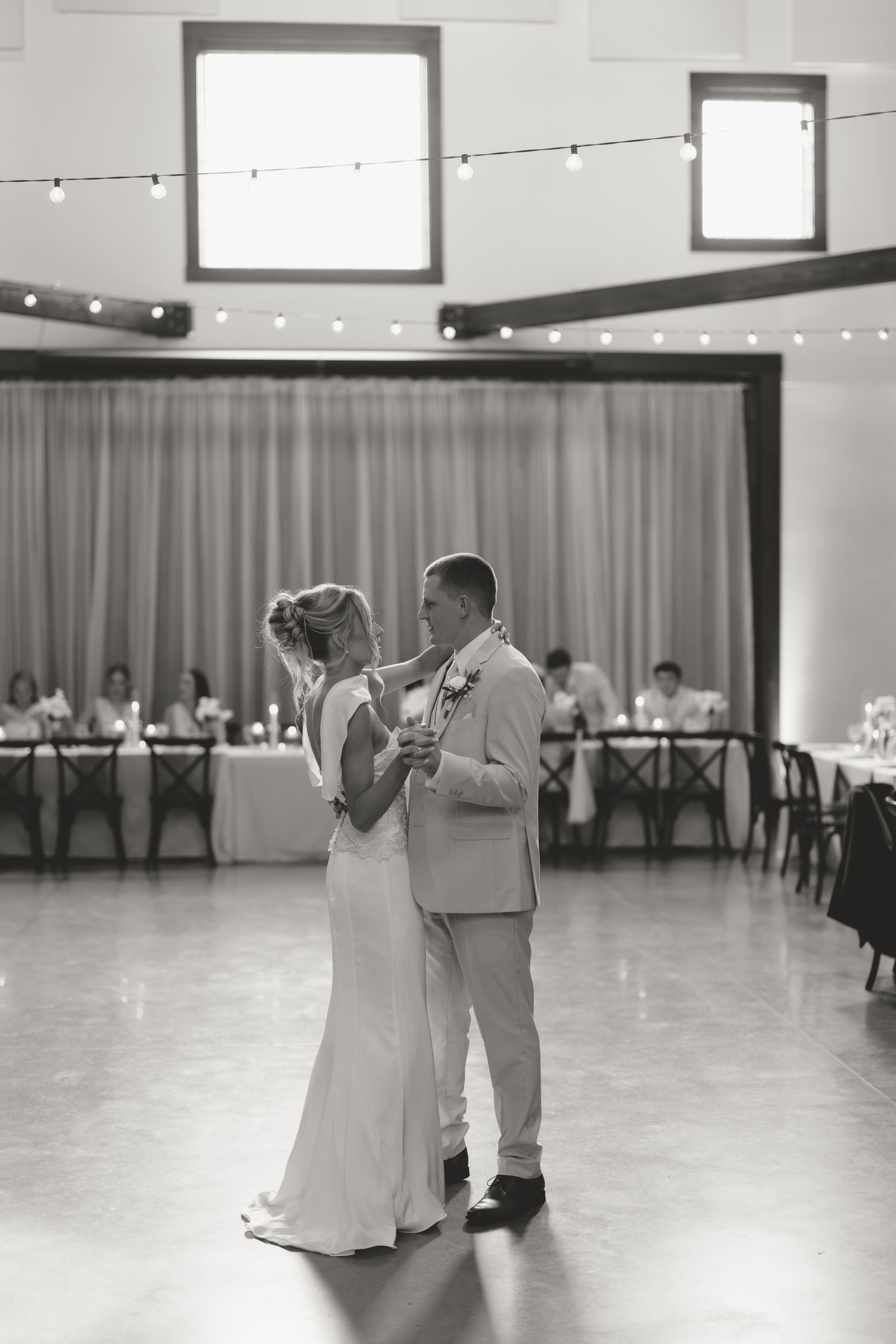 Bride and groom share their first dance in a elegant ballroom during their wedding reception.