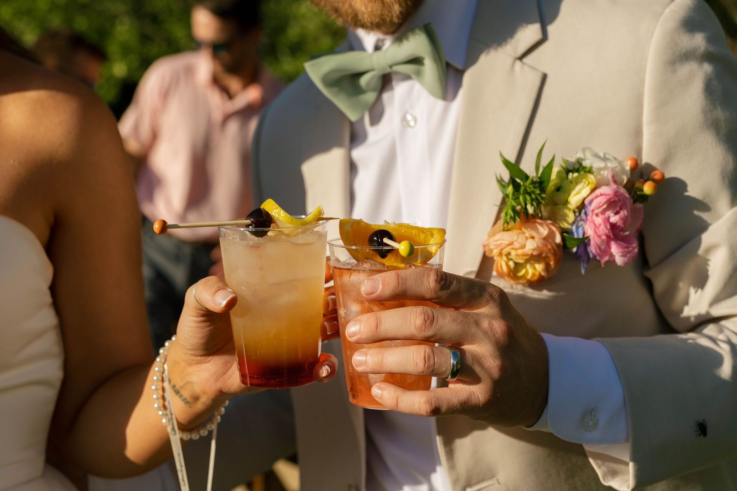 Wedding guests enjoying cocktails and refreshments at an outdoor reception.