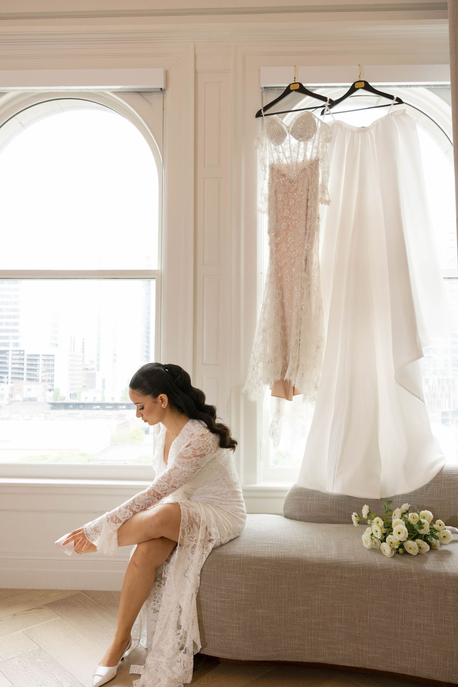 Wedding dress and slip hanging in front of arched windows with natural light during bride getting ready at Union Station in Nashville