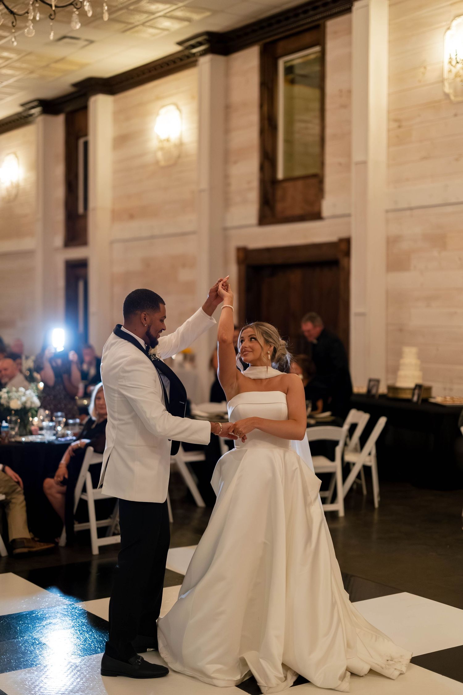 A couple sharing their first dance at a wedding reception in an elegant ballroom.