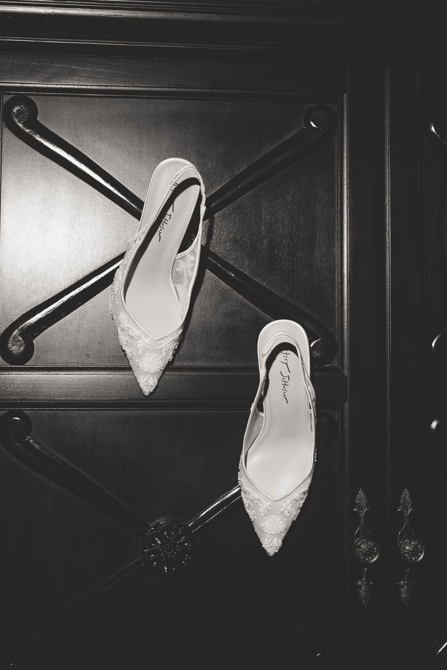 Wedding shoes photographed in dramatic black and white lighting sequence.