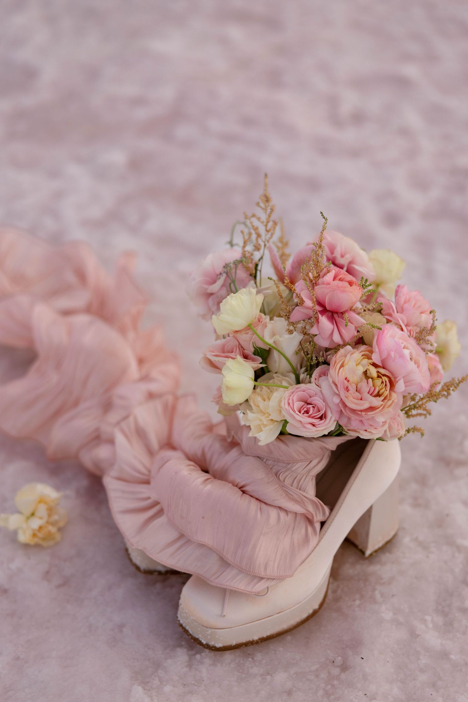 Pink vintage boots decorated with delicate roses and flowers on textured background at the pink lake in Utah