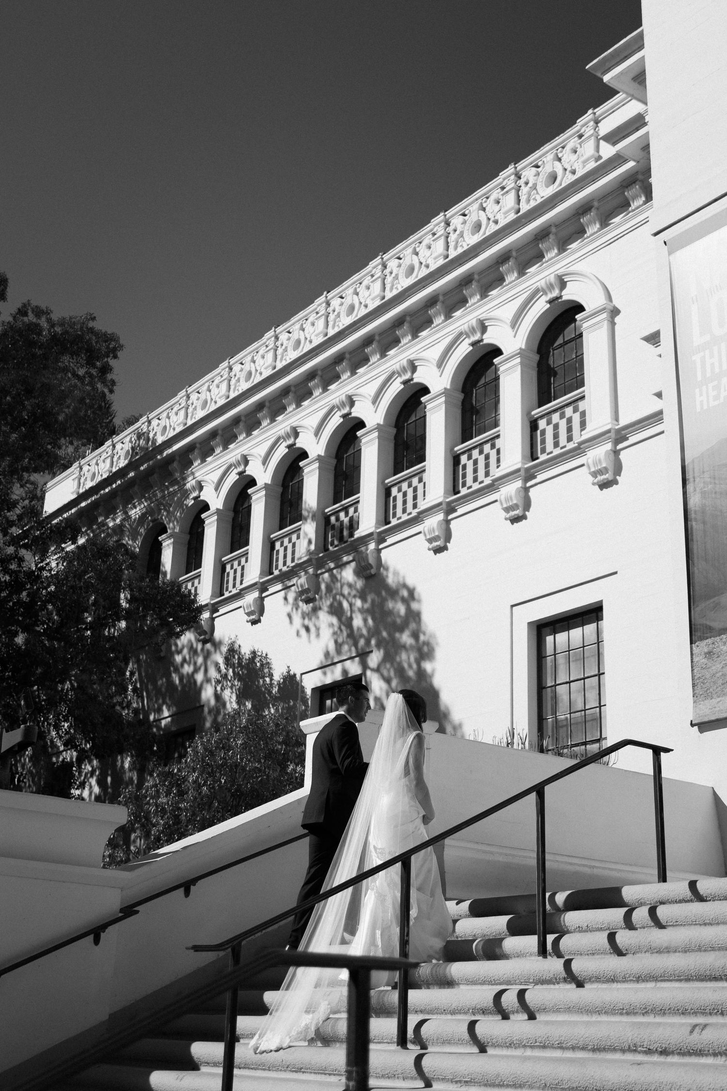 A sequence of black and white photos showing a couple descending grand white steps of a historic building.