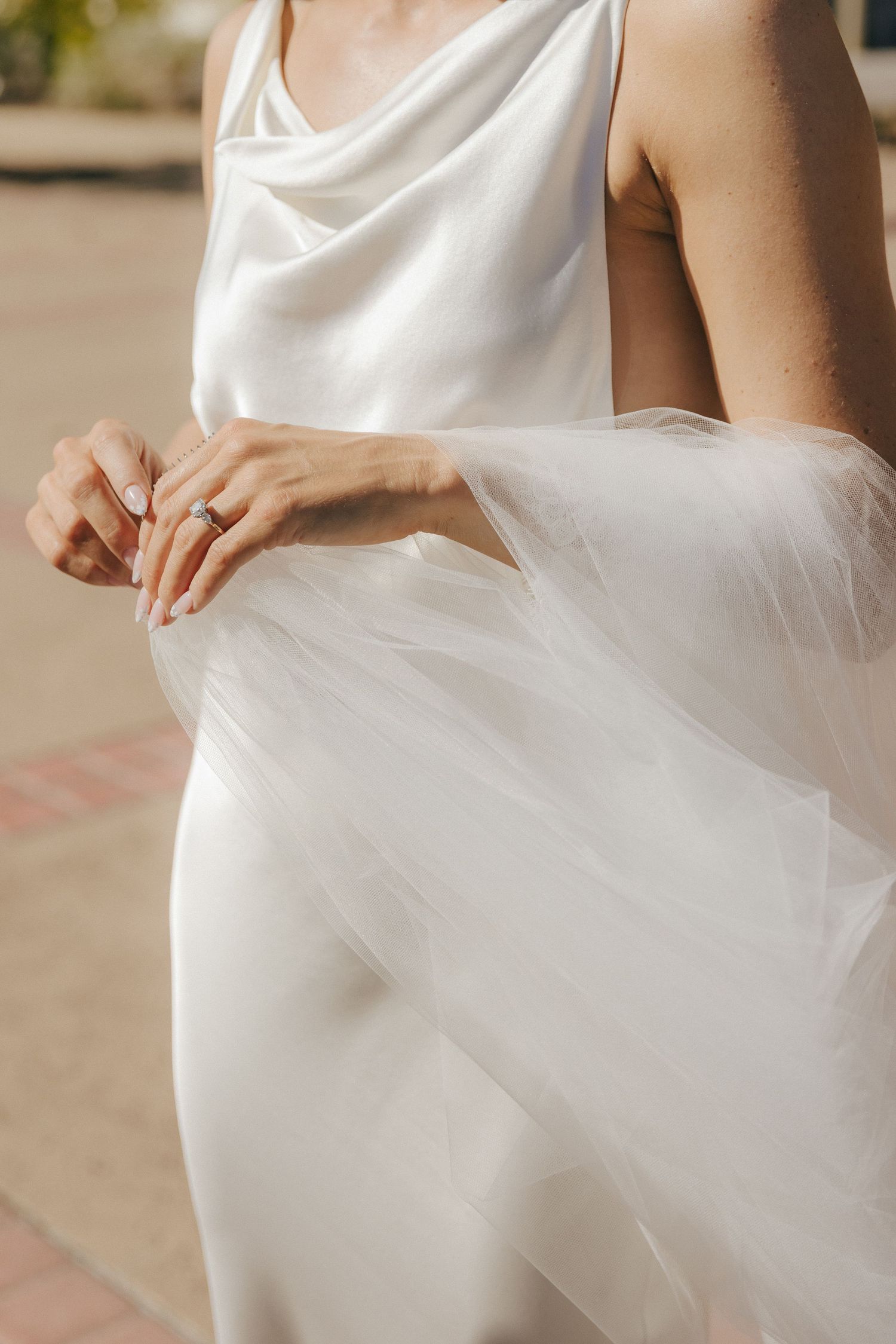 Close-up details of a white tulle wedding dress skirt swaying in elegant movement.