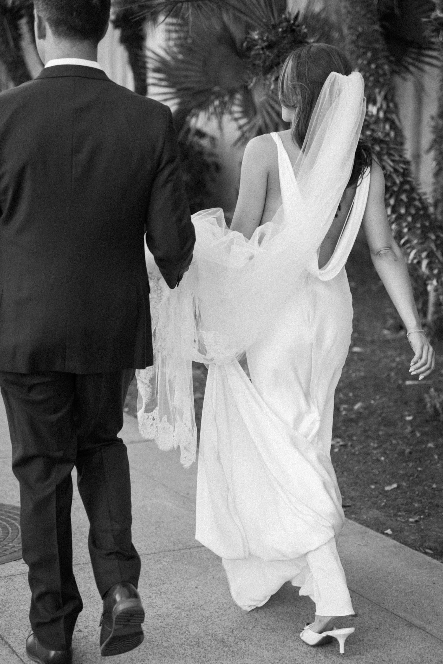 Black and white photos show flowing wedding dress details and shoes as couple walks together.