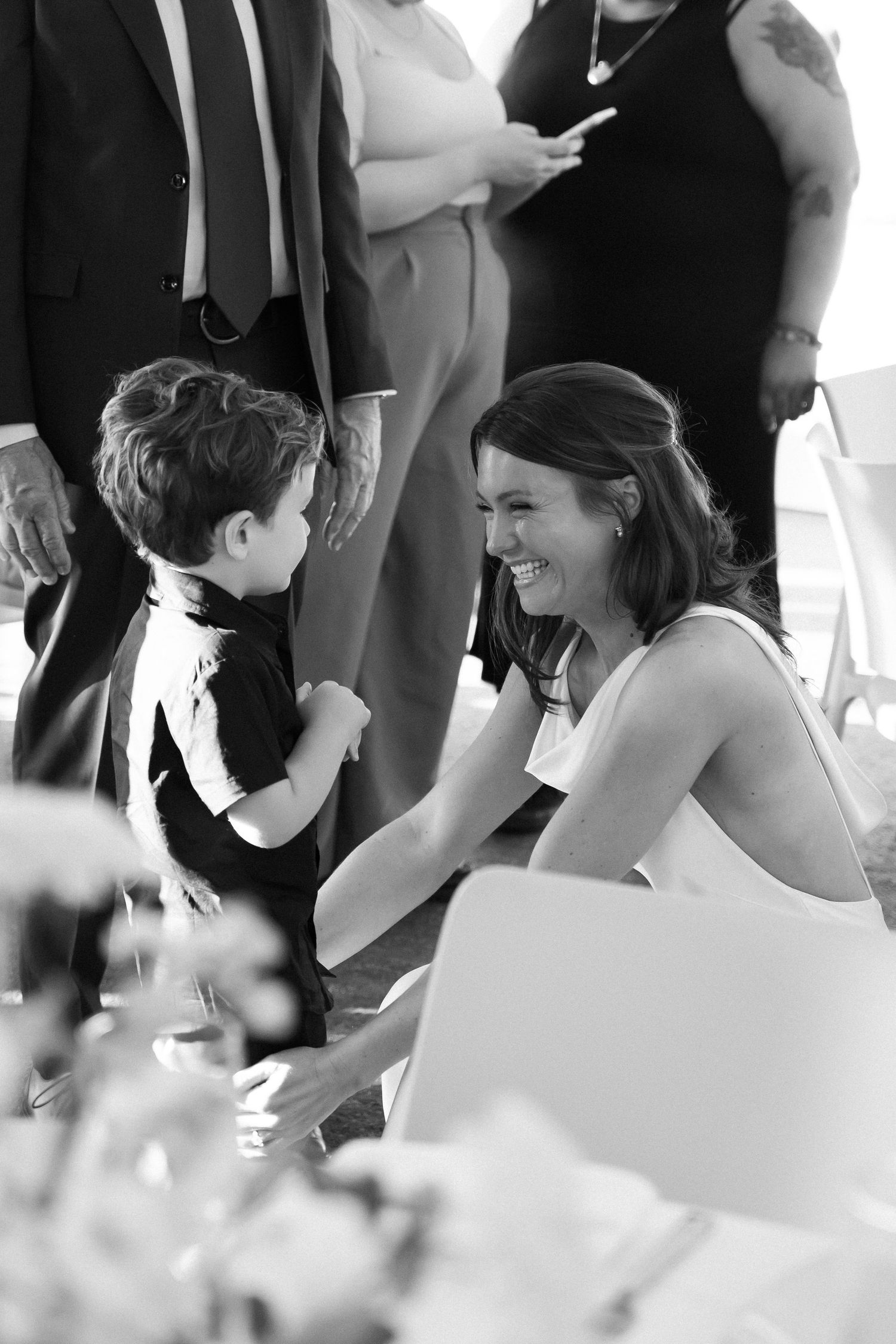 Black and white candid photograph of people engaged in conversation at a formal event.