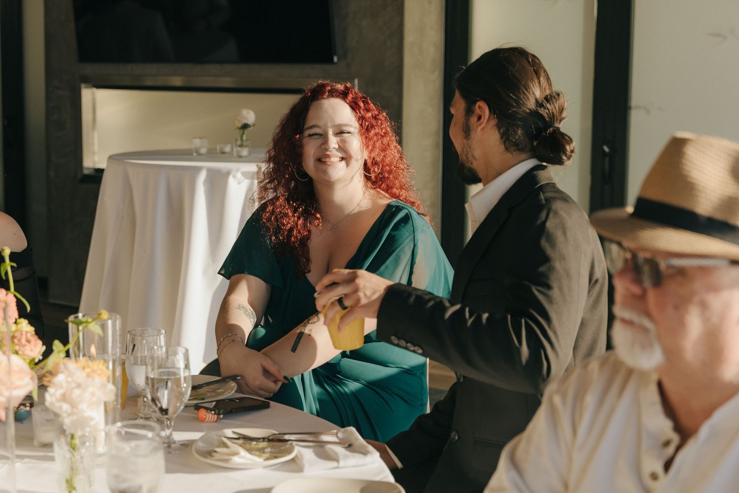 Wedding guests raise glasses in a toast during an elegant indoor reception celebration.