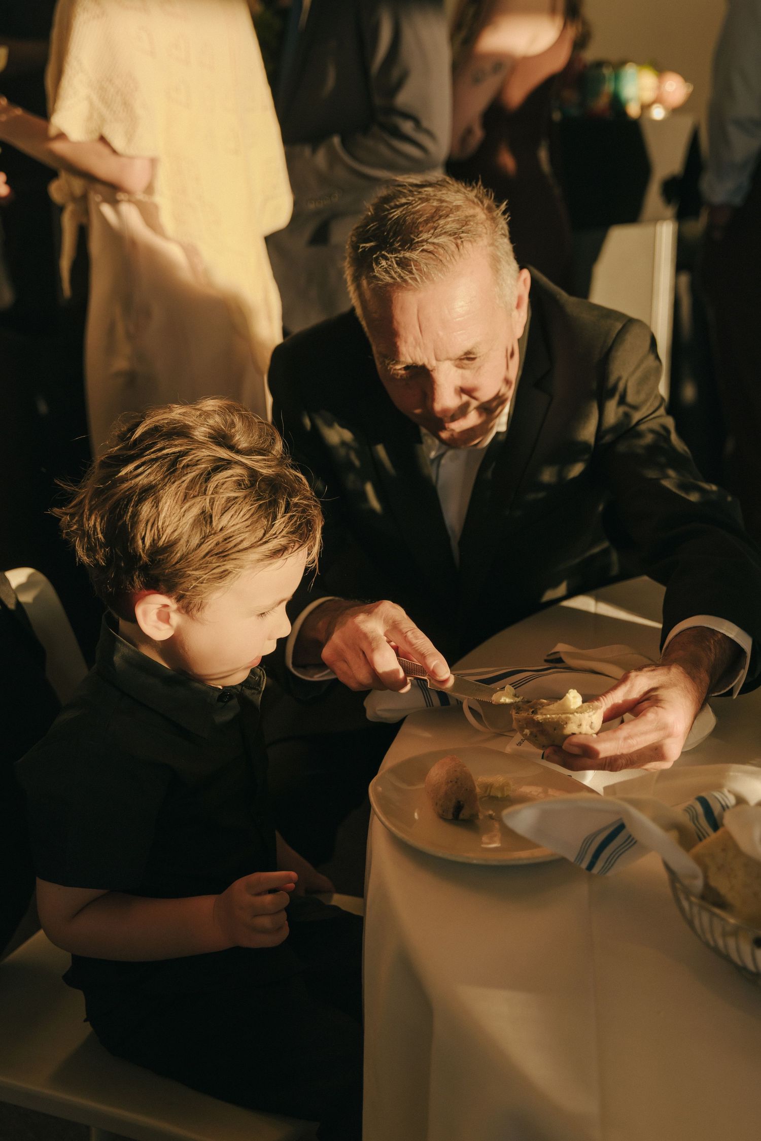 People gathered around a table in a dimly lit restaurant setting examining their food.