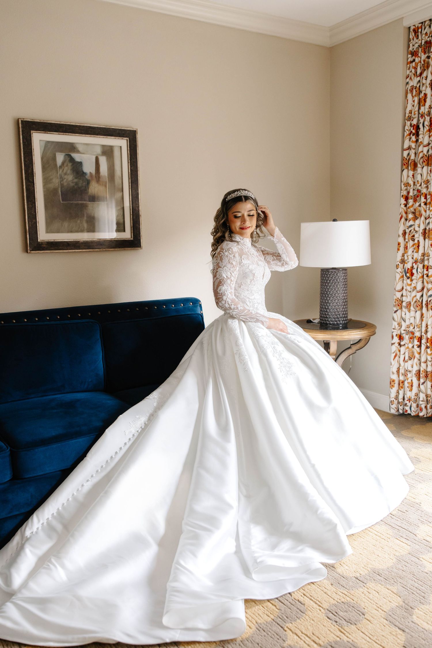 a classic portrait of a bride sitting down on a couch looking away.