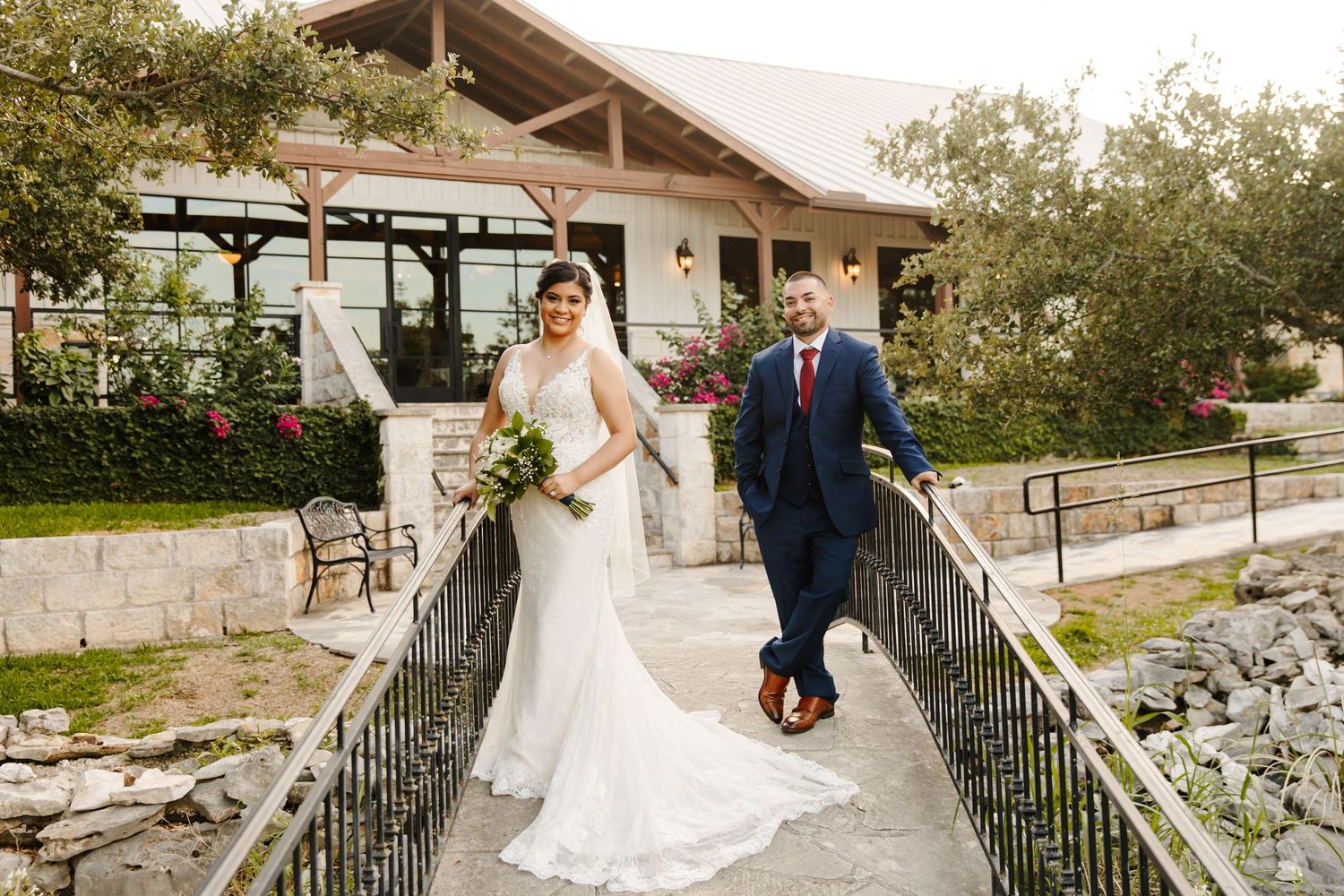 a couple standing side by side in a small bridge at an outdoor wedding venue.