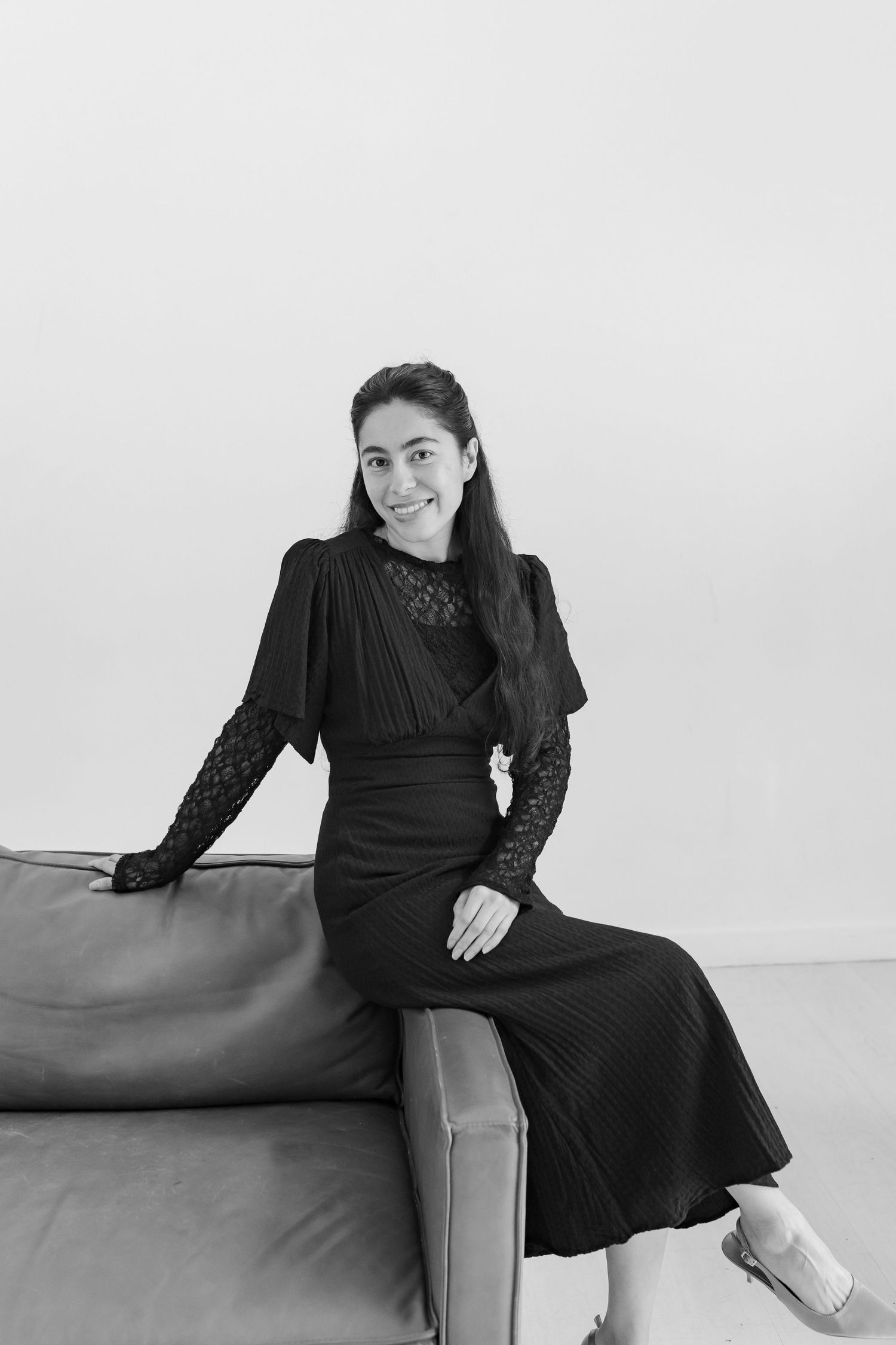 A women sitting on a studio couch posing