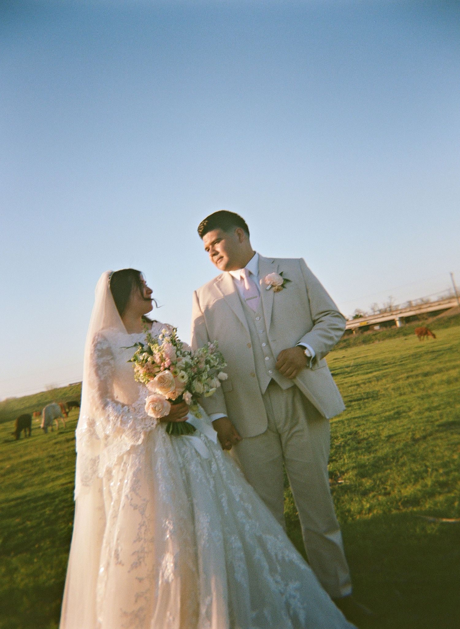 a couple standing in a ranch field captured on holga film
