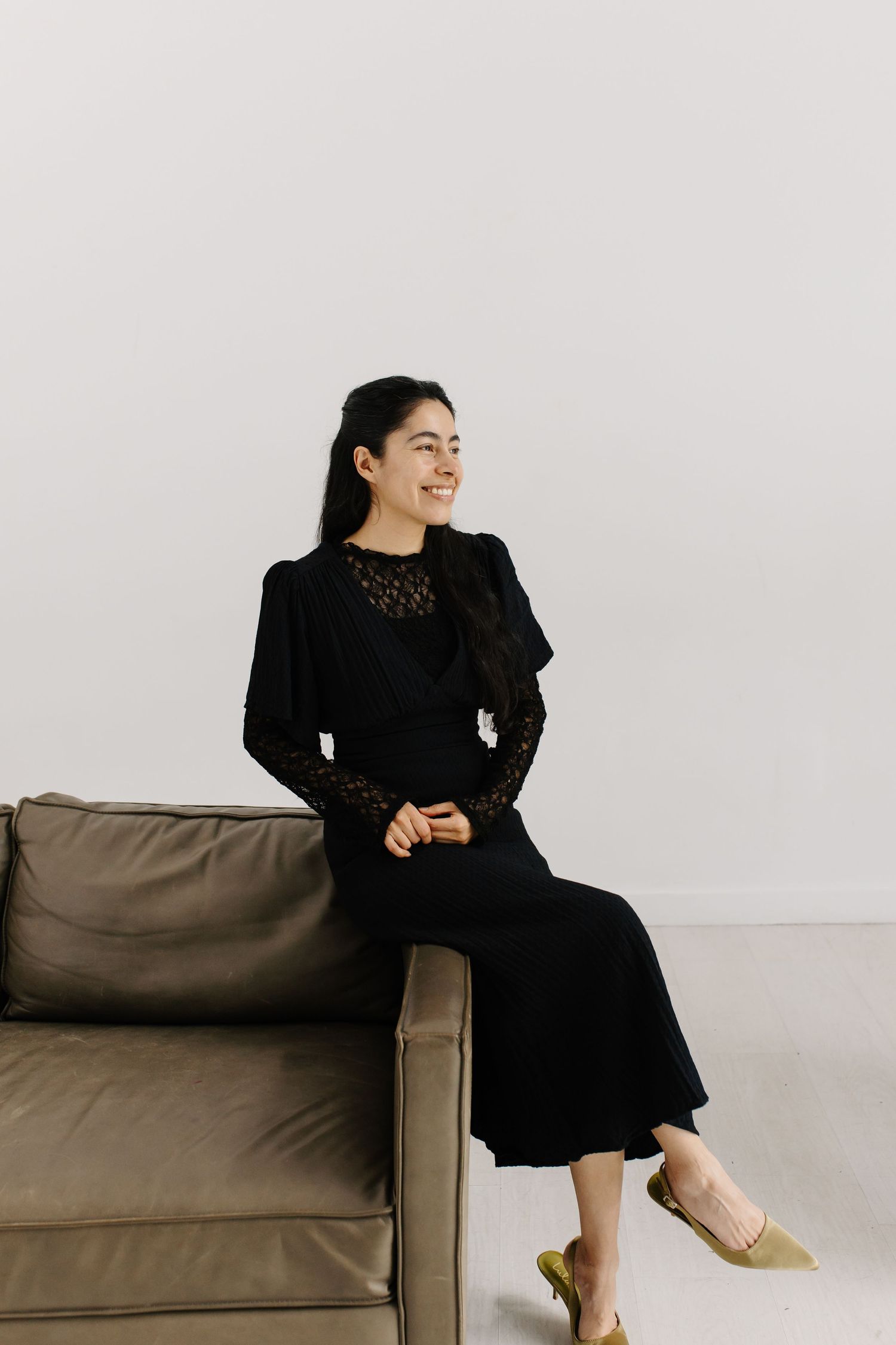 A women sitting on a studio couch posing