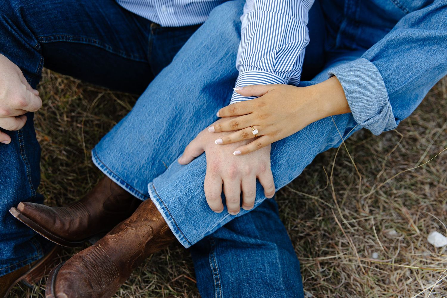 Couples hands on top of each other showing the engagement ring.
