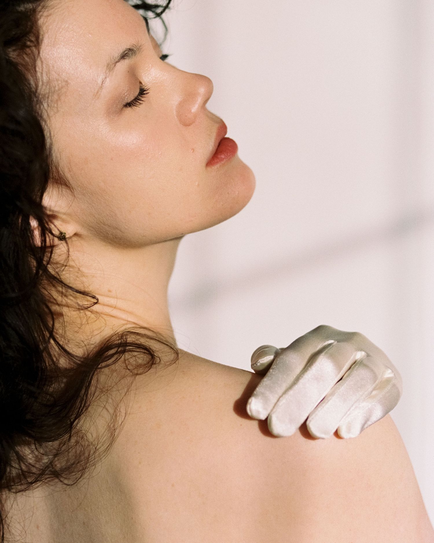 A photo of profile shots showing a neck and shoulder being massaged by white-gloved hands against a light background.