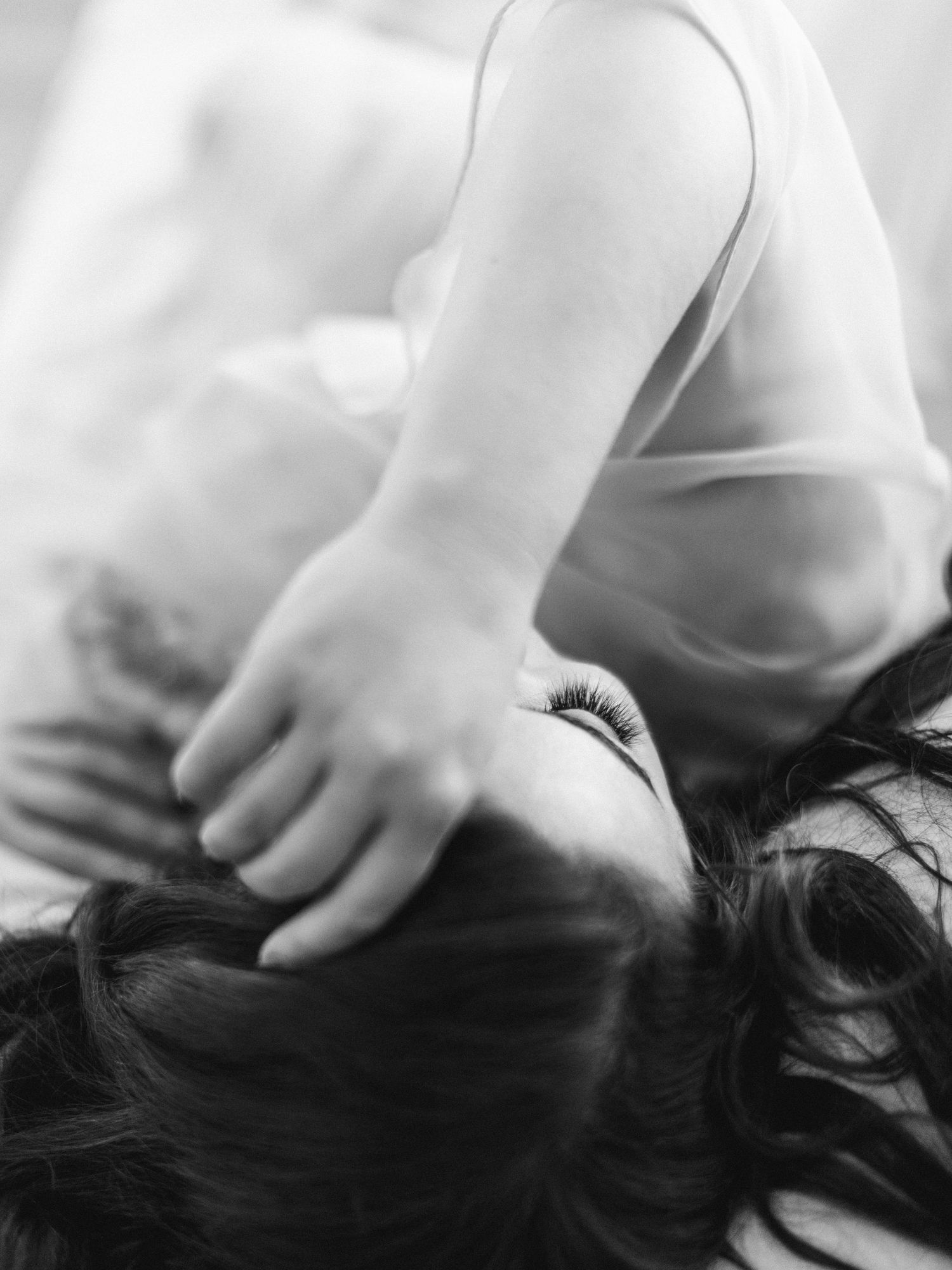 Close black and white portrait of a woman looking up — intimate boudoir photography New York City