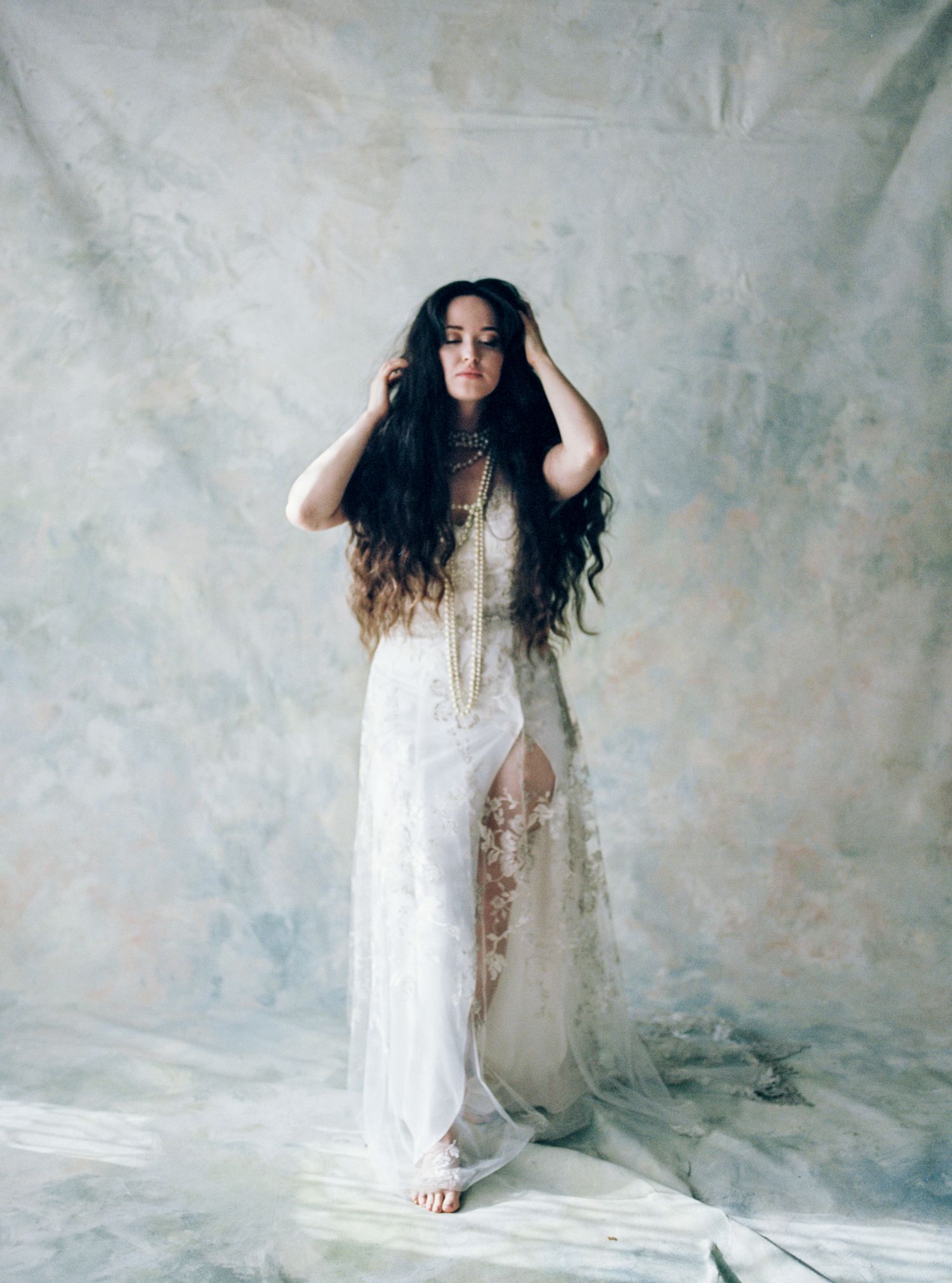 Woman in a white gown standing against a painted backdrop — luxury boudoir photographer New York, Heartmore Artistry