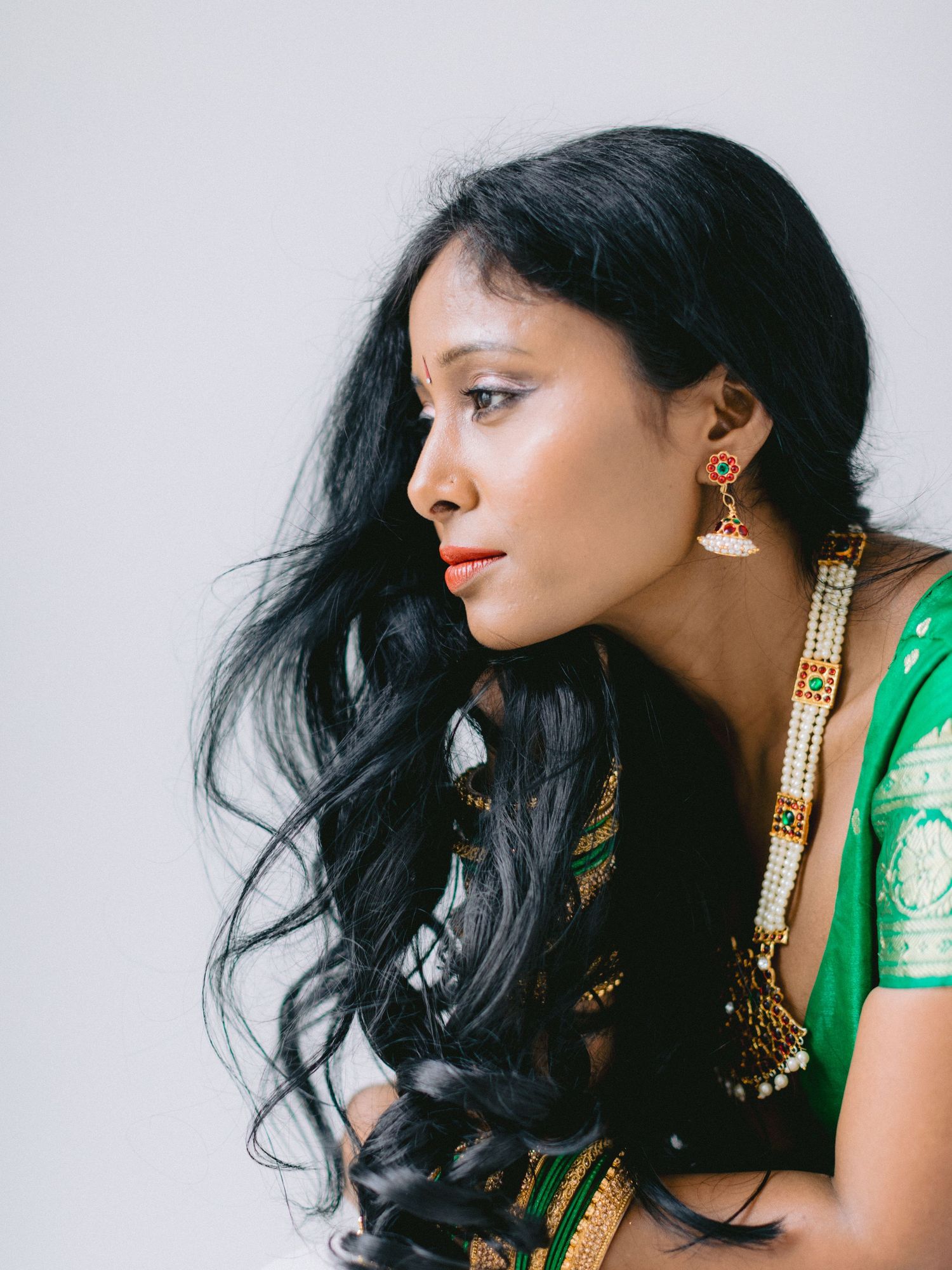 A woman in traditional Indian attire with long black hair poses in a series of artistic profile portraits.