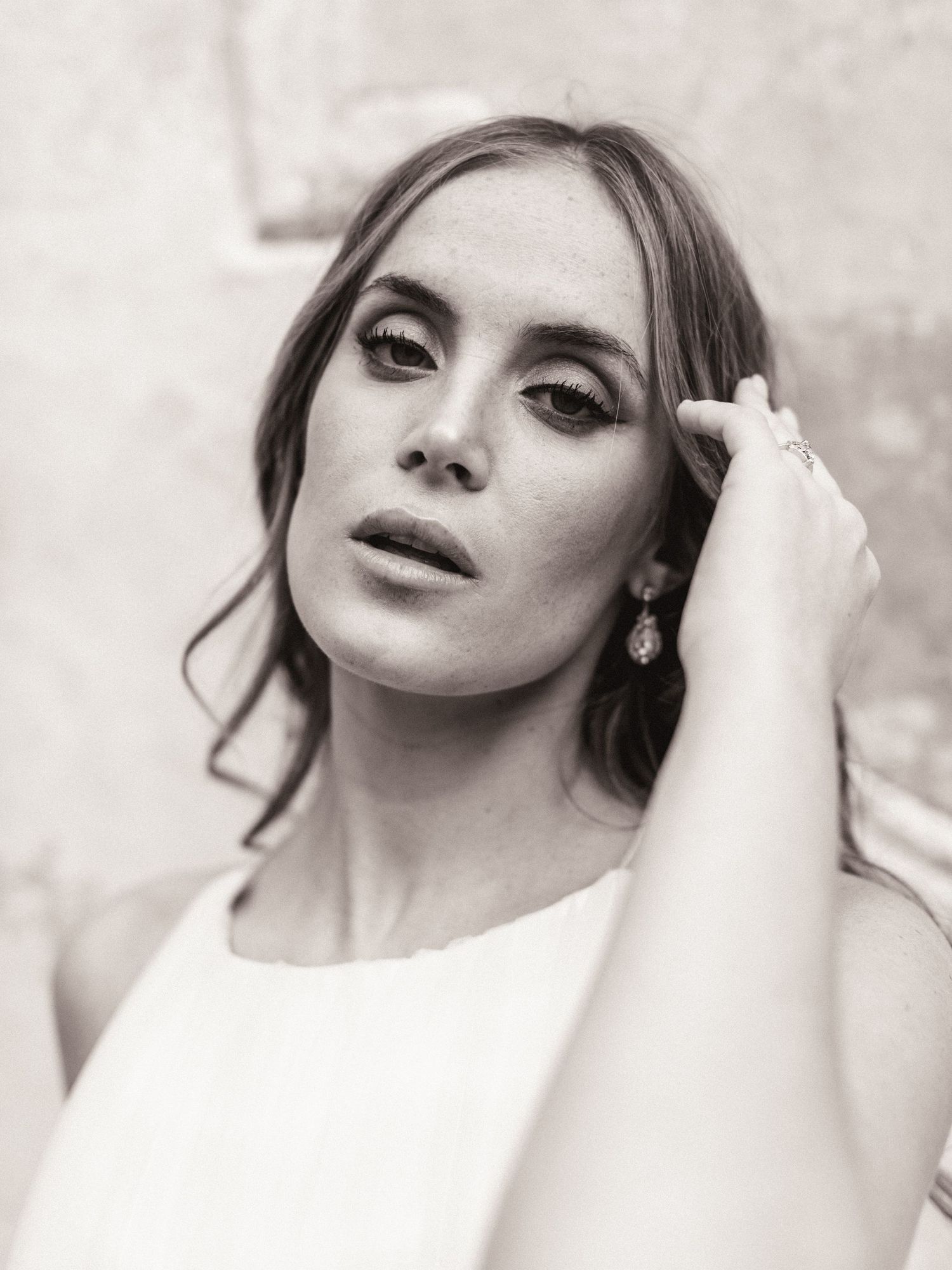 Black and white close-up bridal portrait of woman with elegant updo and dangling earrings.
